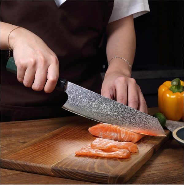 Damascus Kiritsuke chef’s knife cutting through a delicate fish fillet, showcasing its sharpness and precision for fine cuts