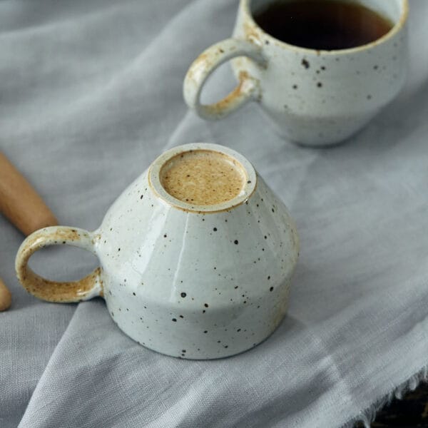 Close-up of a Japanese stoneware coffee cup, showcasing its unique glazed finish and 7.7cm height