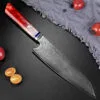 Red resin handle Damascus slicing knife laid out beside fresh ingredients