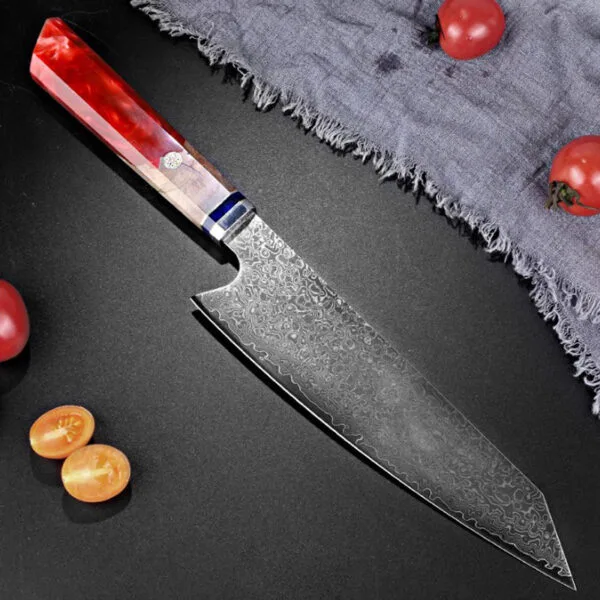 Red resin handle Damascus slicing knife laid out beside fresh ingredients