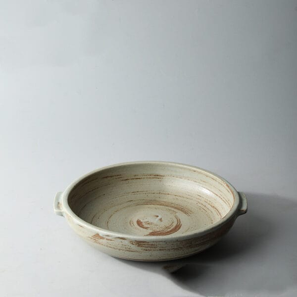 Close-up of a brown stoneware serving plate, featuring its durable ceramic material and vintage design